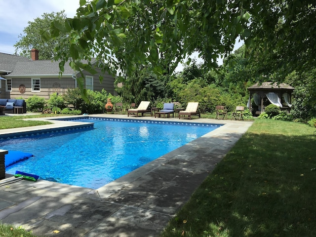 outdoor pool featuring a grill, a lawn, and a gazebo