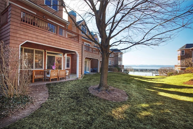 view of yard featuring a water view, a balcony, and central air condition unit