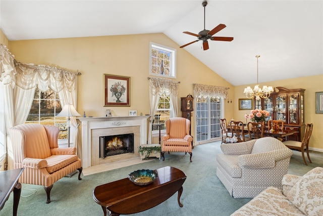 carpeted living area featuring ceiling fan with notable chandelier, high vaulted ceiling, and a fireplace