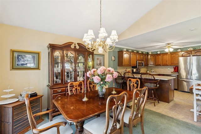 dining space with light tile patterned flooring, vaulted ceiling, and ceiling fan with notable chandelier