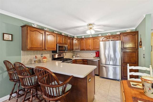 kitchen featuring tasteful backsplash, stainless steel appliances, light countertops, and light tile patterned flooring