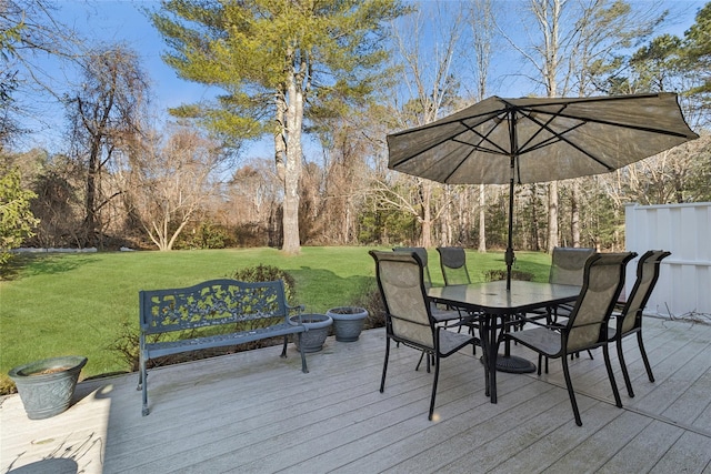 deck featuring outdoor dining area and a yard