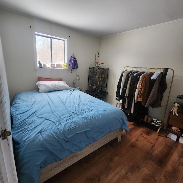 bedroom with wood finished floors and crown molding