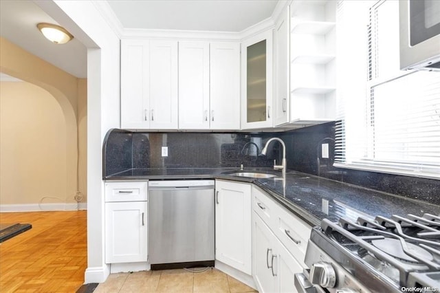 kitchen featuring open shelves, stainless steel appliances, decorative backsplash, white cabinets, and a sink