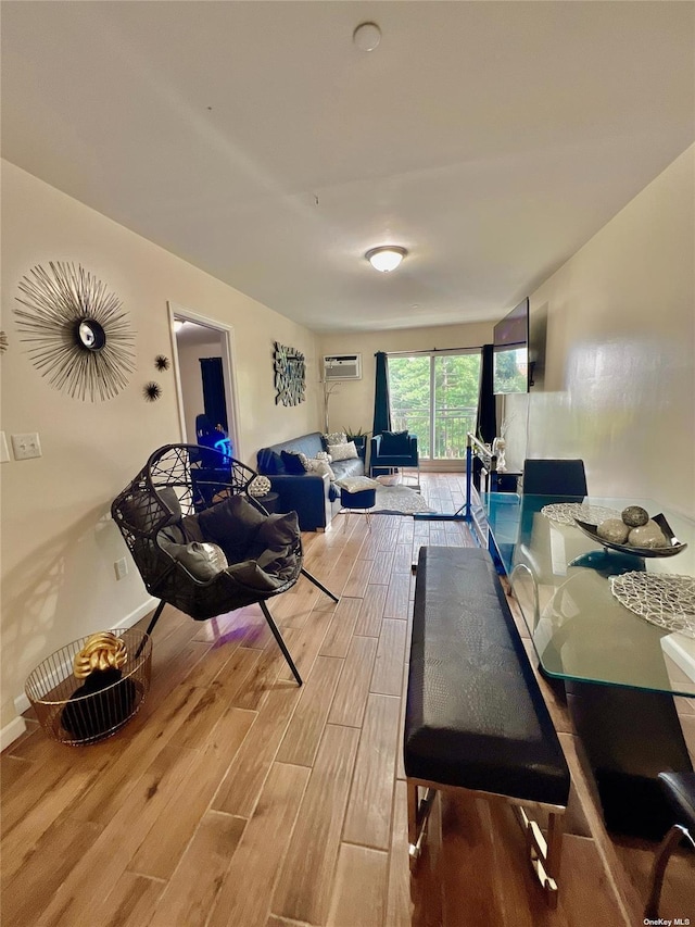 dining area featuring baseboards, a wall unit AC, and light wood finished floors