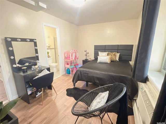 bedroom featuring light wood-style floors, connected bathroom, and baseboards