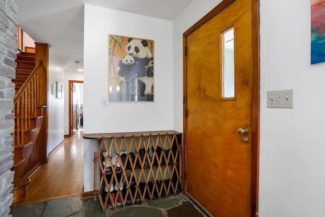 foyer with stairs, baseboards, and wood finished floors