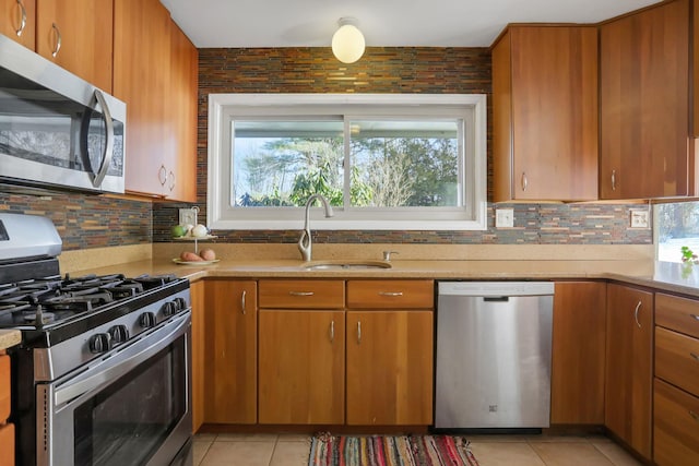 kitchen with light countertops, appliances with stainless steel finishes, plenty of natural light, and a sink