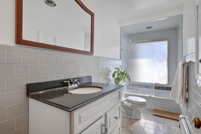 bathroom featuring tile walls, visible vents, a baseboard heating unit, washtub / shower combination, and vanity