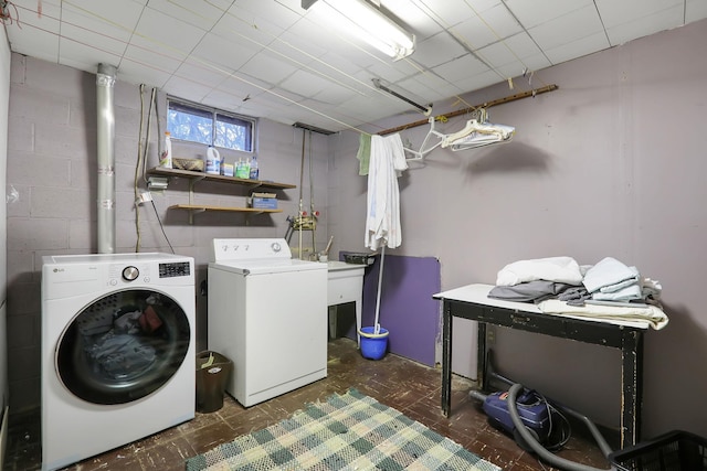 laundry room featuring laundry area, washer and clothes dryer, and concrete block wall