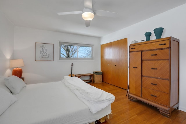 bedroom featuring ceiling fan, a closet, and light wood-type flooring