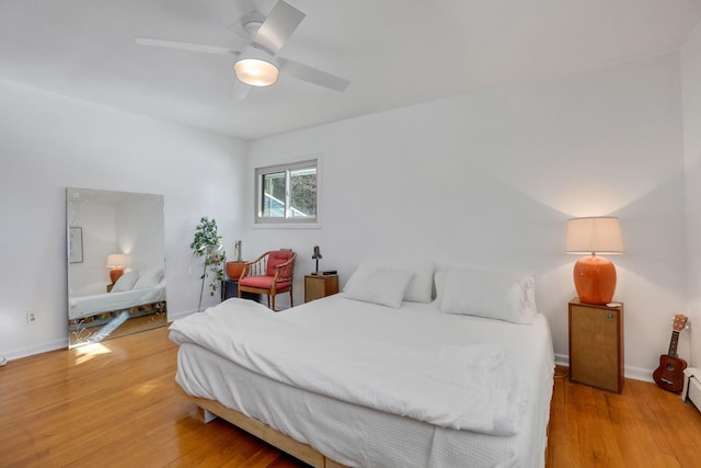 bedroom with light wood-style floors, baseboards, and a ceiling fan