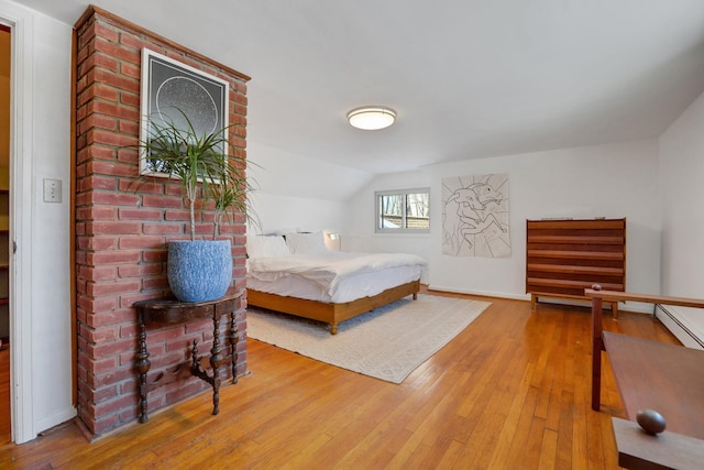 bedroom featuring vaulted ceiling, baseboards, and wood finished floors