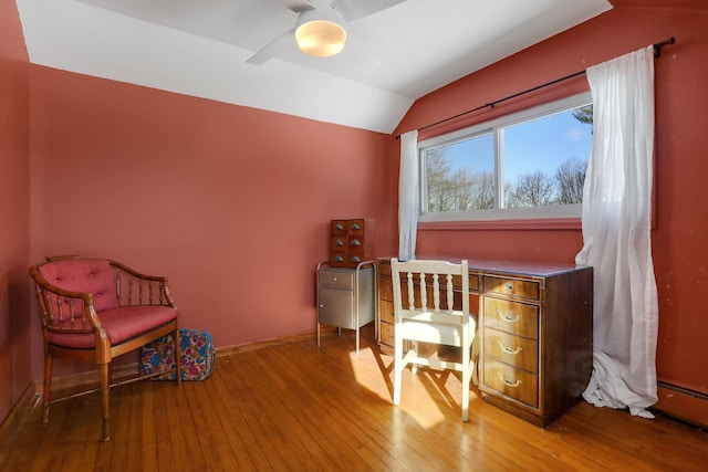 home office featuring baseboards, a ceiling fan, lofted ceiling, baseboard heating, and light wood-style floors