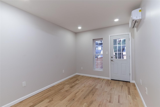 entryway featuring light wood-style floors, recessed lighting, baseboards, and a wall mounted AC