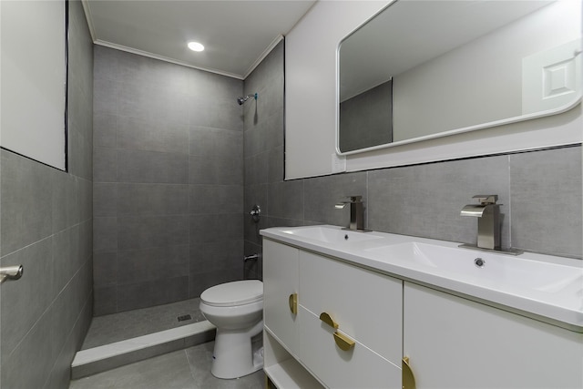 full bathroom featuring a sink, tile walls, toilet, and double vanity