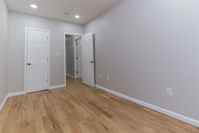 unfurnished bedroom featuring recessed lighting, light wood-style flooring, and baseboards