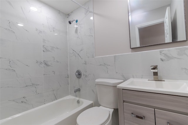 bathroom featuring toilet, shower / tub combination, tile walls, and vanity