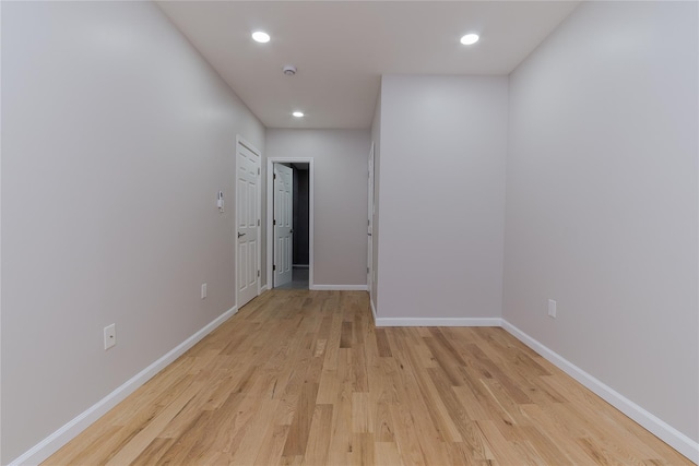 hallway featuring light wood-type flooring, baseboards, and recessed lighting