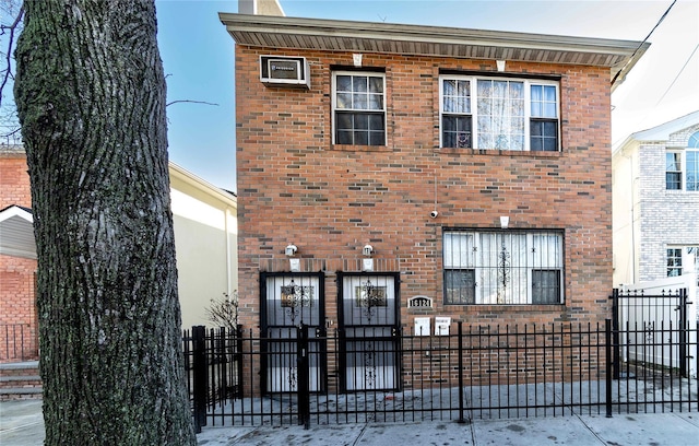 view of front of house featuring a fenced front yard, a gate, and brick siding