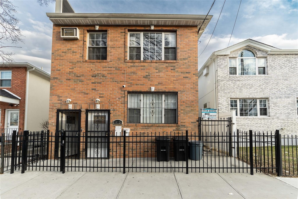 view of front facade featuring brick siding, a fenced front yard, and a gate