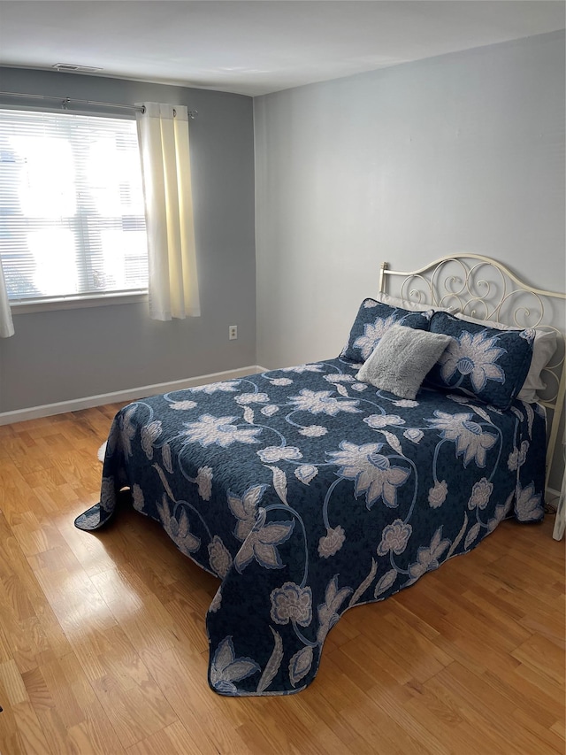 bedroom with baseboards and wood finished floors