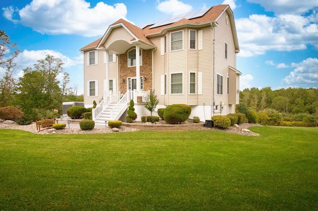 84 Kings Rd, Rock Tavern, NY 12575 - view of front of house with solar panels, a front yard, a patio area, and stone siding