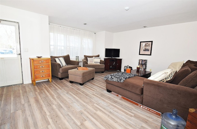 living area with visible vents and light wood-style flooring