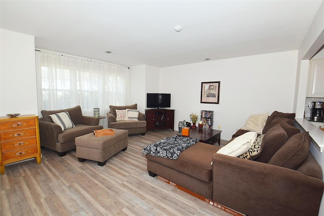 living area with light wood-type flooring and visible vents