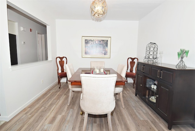 dining space with baseboards and light wood finished floors