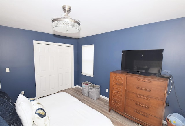 bedroom with a closet, baseboards, and wood finished floors