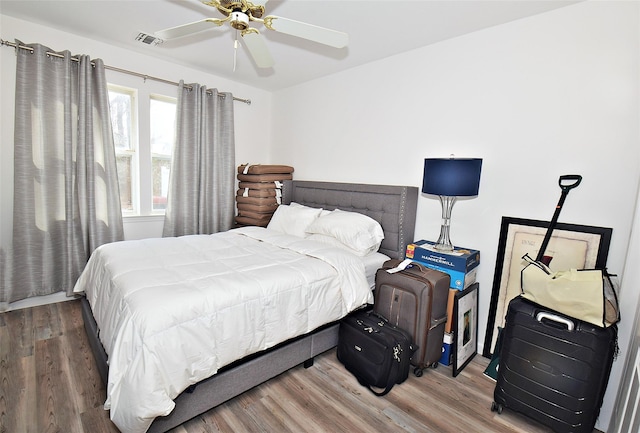 bedroom featuring ceiling fan, wood finished floors, and visible vents