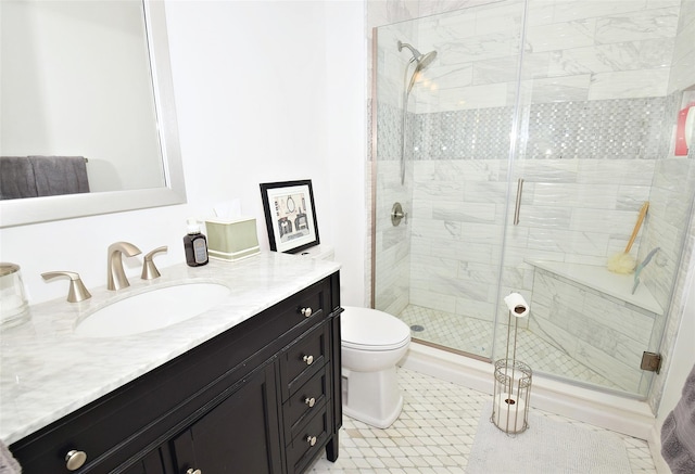 full bathroom featuring a stall shower, vanity, and toilet