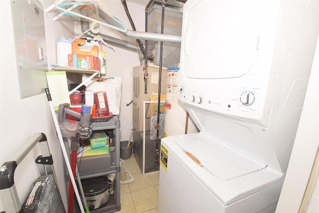 laundry area with water heater, laundry area, light tile patterned floors, and stacked washer / dryer