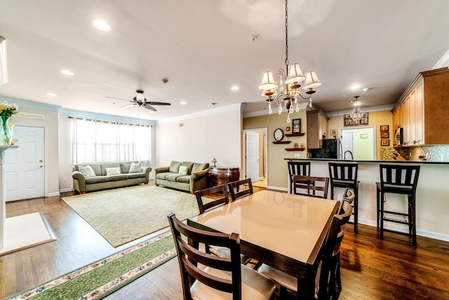 dining room featuring ceiling fan with notable chandelier, dark wood-style flooring, and crown molding