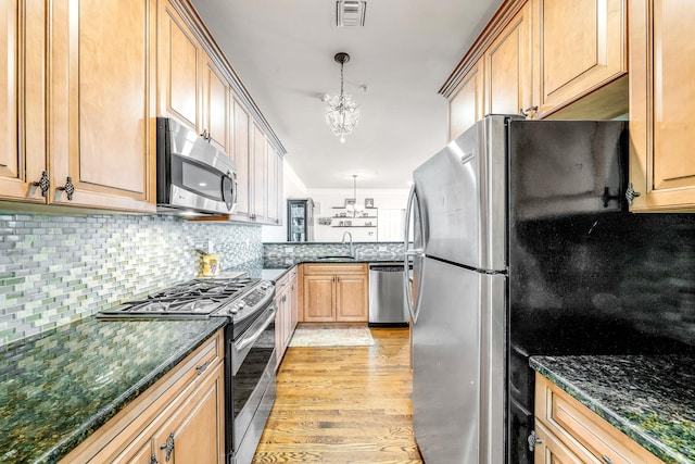 kitchen featuring light wood finished floors, visible vents, appliances with stainless steel finishes, an inviting chandelier, and pendant lighting