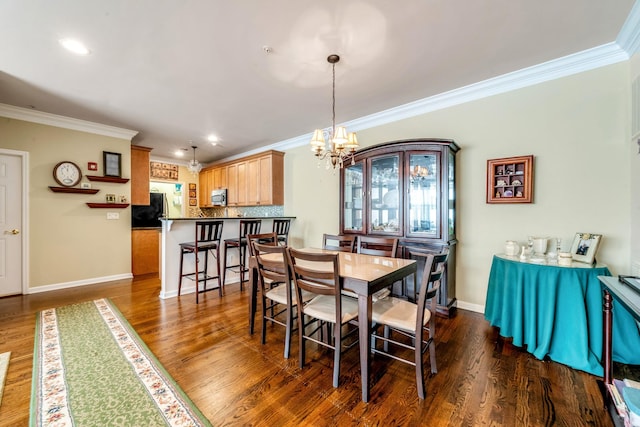 dining space with dark wood-style floors, ornamental molding, an inviting chandelier, and baseboards