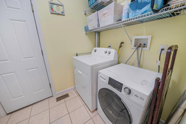 laundry room featuring laundry area, visible vents, washer and dryer, and light tile patterned flooring