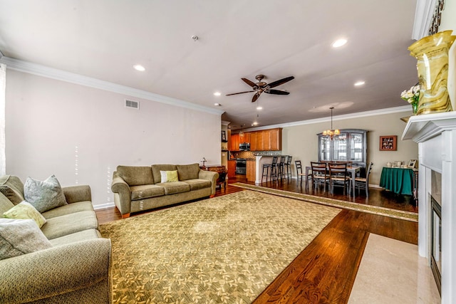 living room with ornamental molding, wood finished floors, and recessed lighting