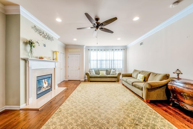 living area with light wood finished floors, baseboards, crown molding, and a high end fireplace