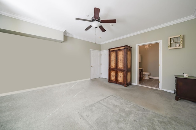 unfurnished bedroom featuring baseboards, ornamental molding, ensuite bath, and light colored carpet