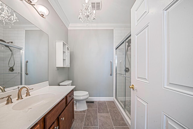 bathroom with a notable chandelier, vanity, toilet, and crown molding