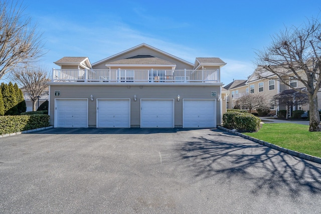 view of front of property with a balcony, driveway, and a garage