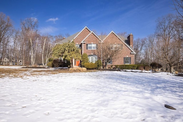 view of front of home with brick siding and a chimney