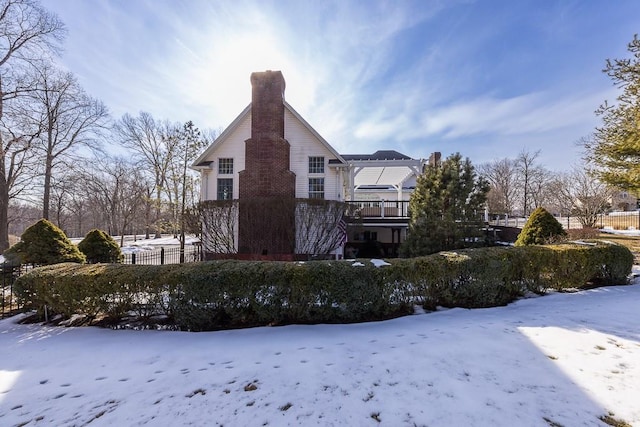 snow covered property with a chimney