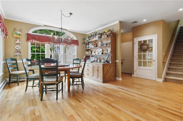 dining space with ornamental molding, an inviting chandelier, light wood finished floors, and stairs