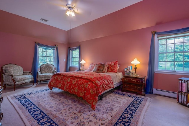 bedroom with lofted ceiling, light colored carpet, visible vents, baseboard heating, and a ceiling fan