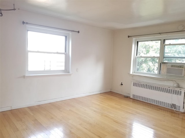 111-16 66th Ave Unit 3C, Forest Hills, NY 11375 - empty room with baseboards, light wood finished floors, cooling unit, and radiator