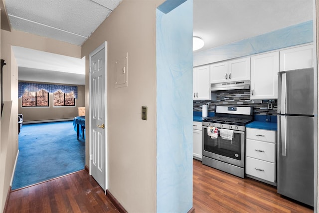 kitchen featuring dark wood-type flooring, under cabinet range hood, appliances with stainless steel finishes, white cabinetry, and tasteful backsplash