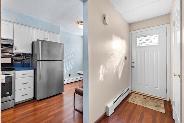 kitchen featuring baseboard heating, white cabinetry, stainless steel appliances, and ventilation hood